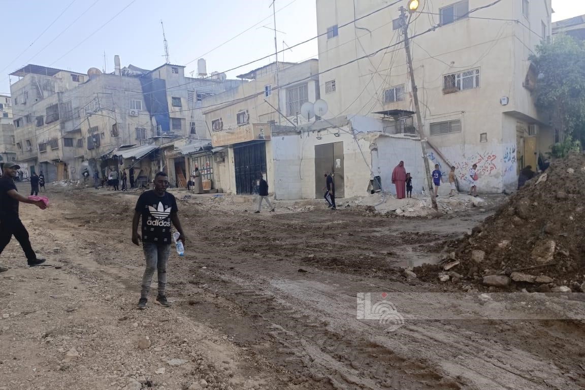 مواطنون يتفقدون آثار الدمار الذي خلفه الاحتلال الإسرائيلي في مخيم طولكرم (تصوير: وفا عواد/وفا)